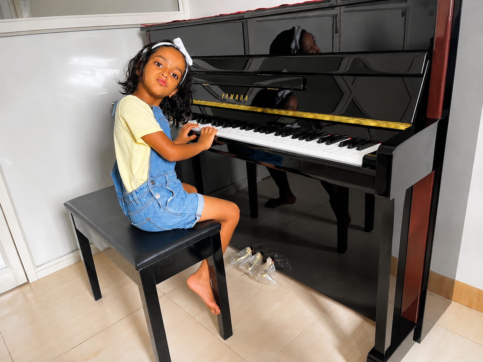 A young student at the upright piano during a lesson